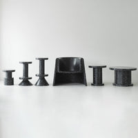 Modern black furniture set featuring various shapes and textures, showcasing sleek patterns and a minimalist design.