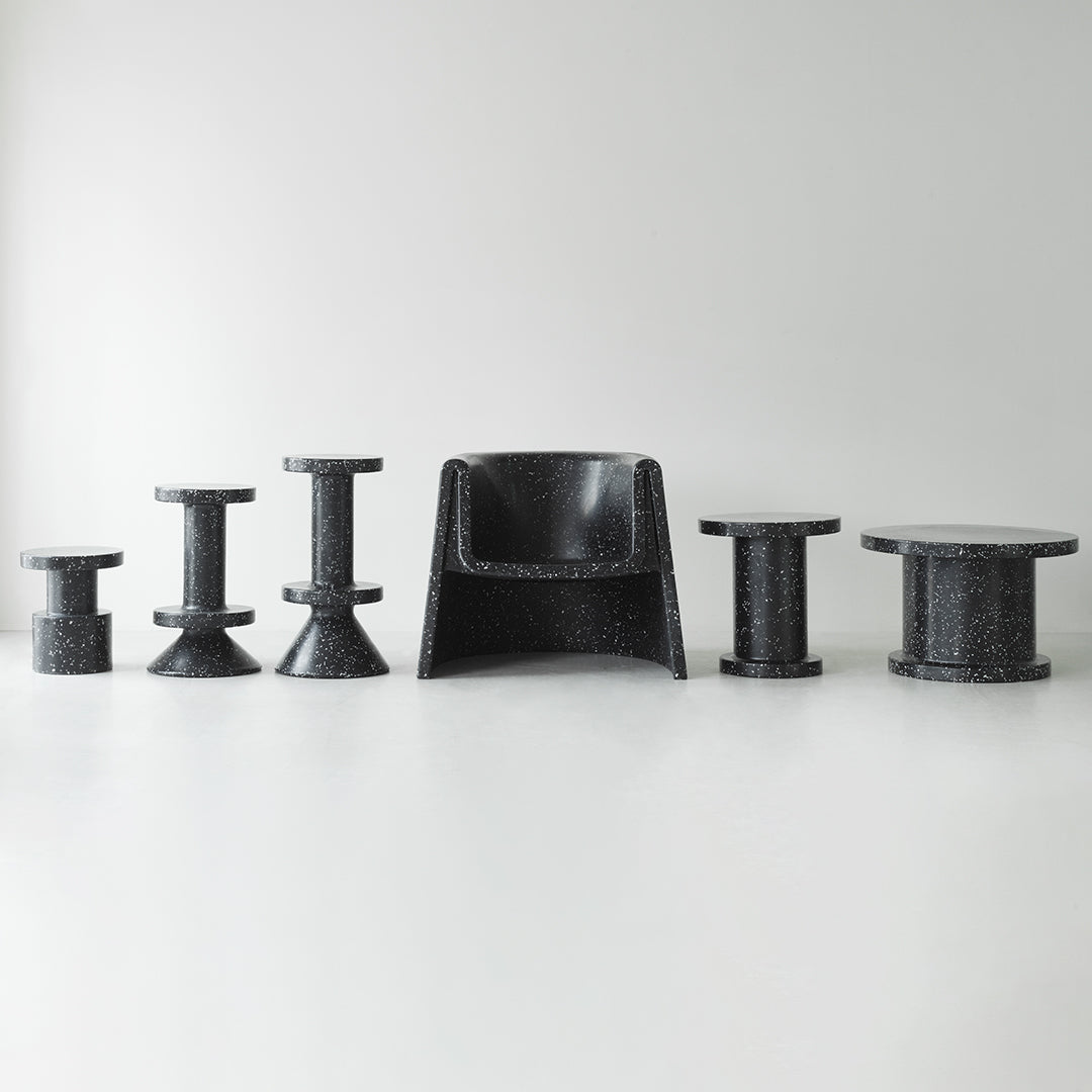Black furniture set featuring various geometric shapes and textures against a light background. Modern and sleek design.