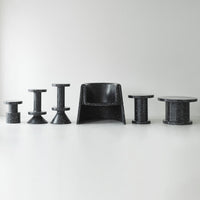 Black furniture set featuring various geometric shapes and textures against a light background. Modern and sleek design.