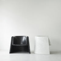 Black and white chairs with smooth, modern designs; black textured surface and white speckled finish.