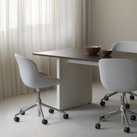 "Soft gray chairs with white fabric, modern wooden table, and sleek minimalist design in a light, airy setting."