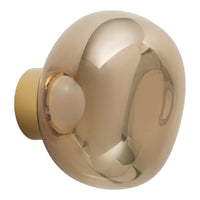 "Glossy amber glass wall sconce with a smooth, rounded design and matte beige base."