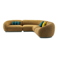 Curved sofa in textured mustard with teal and yellow accent pillows, featuring a cozy, modern pattern.