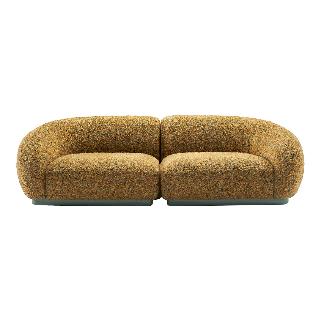 Curved two-tone sofa in warm orange and brown textured fabric with subtle multi-colored flecks.