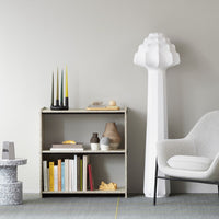 Neutral-toned shelving unit with a textured finish, featuring colorful accents in yellow, white, and earthy patterns.