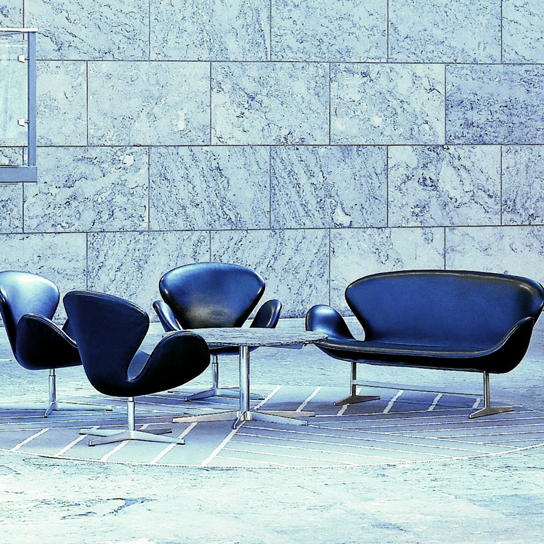 Modern blue seating set against a textured gray stone wall, featuring sleek curves and minimalist design.