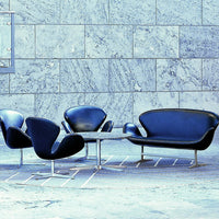 Modern blue seating set against a textured gray stone wall, featuring sleek curves and minimalist design.