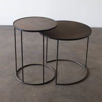 Two round side tables with dark wood tops and black metal frames, featuring a sleek, modern design.