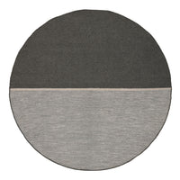 Round area rug featuring a split design in dark gray and light gray, showcasing modern, minimalist patterns.