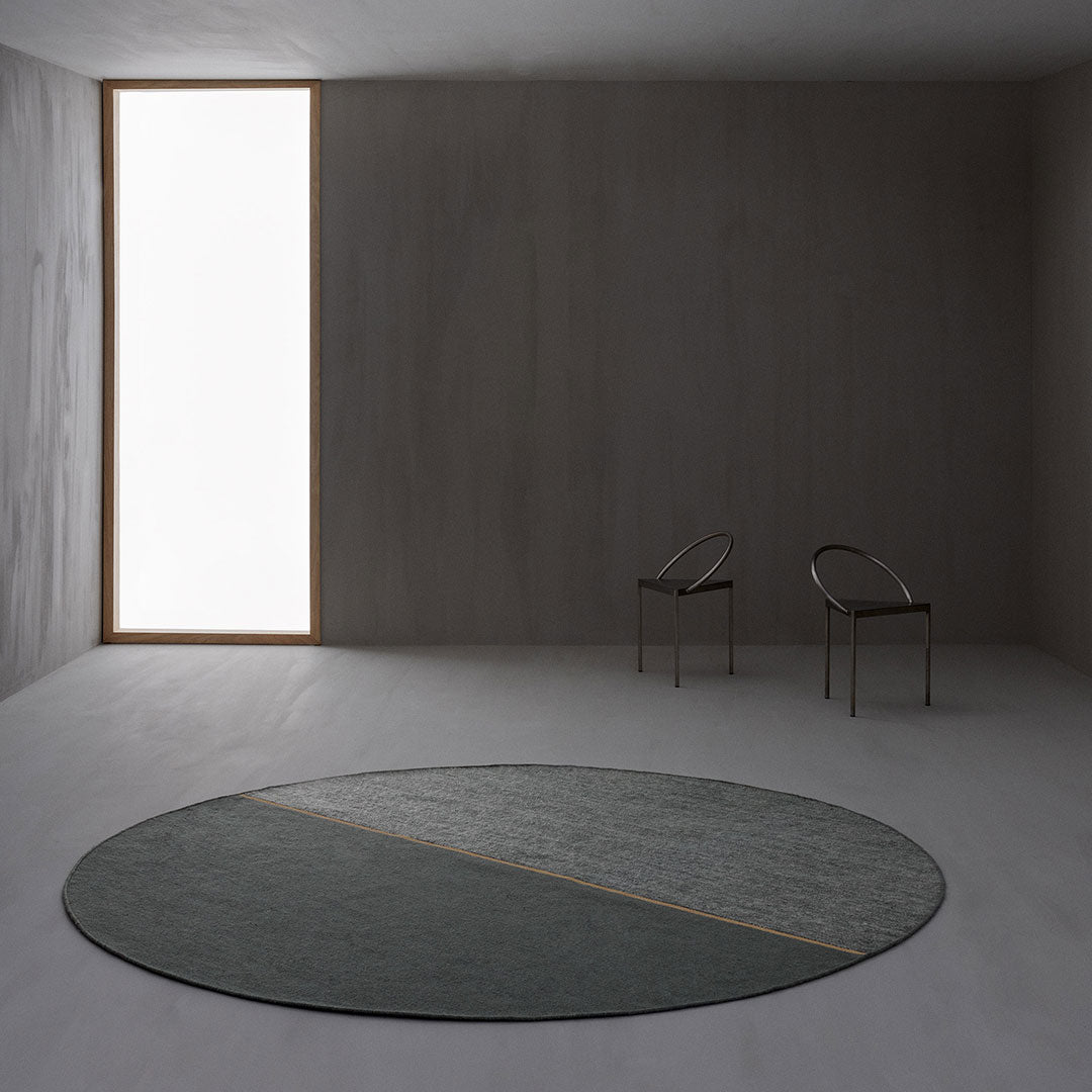 Round rug in muted gray tones with a subtle diagonal pattern, featuring a sleek minimalist design.