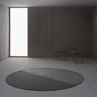 Round rug in muted gray tones with a subtle diagonal pattern, featuring a sleek minimalist design.