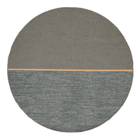 Round rug featuring a smooth gray top half and textured teal bottom half with a subtle wooden accent line.