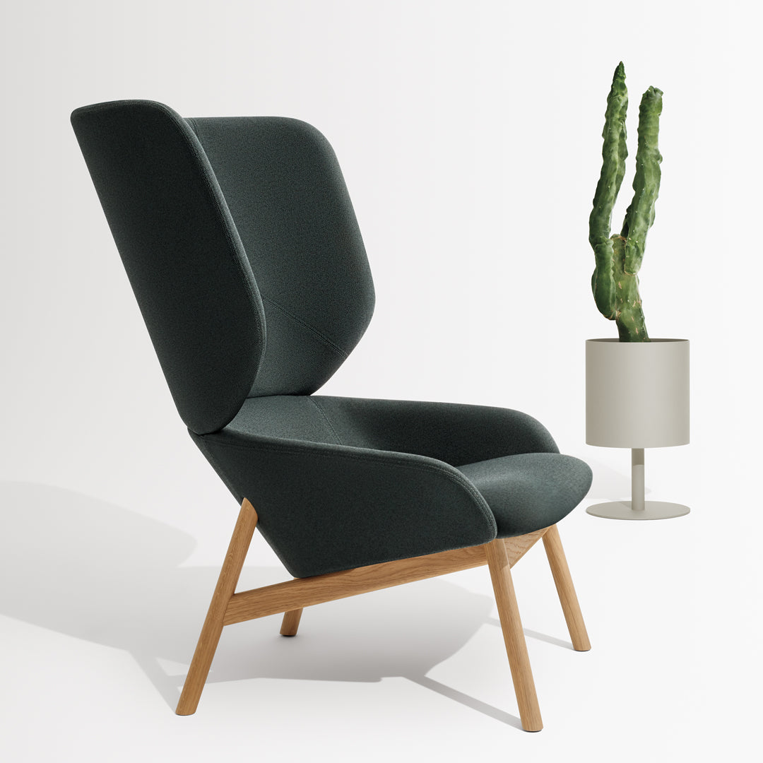 Dark green modern chair with sleek lines and light wooden legs, complemented by a minimalist planter.