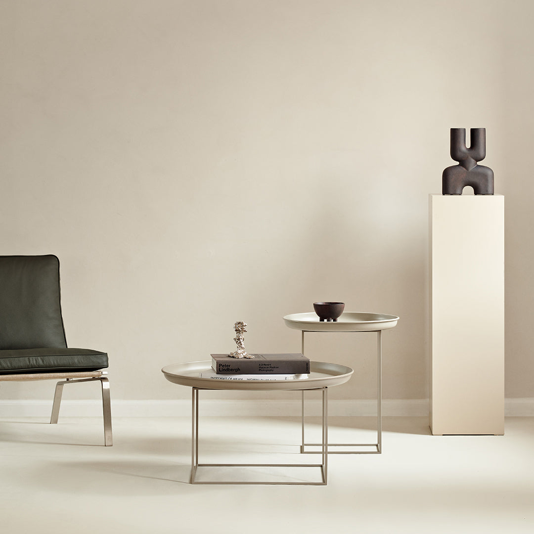 Modern round coffee tables with marble tops, gray and silver accents, set against a neutral beige background.