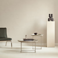 Modern round coffee tables with marble tops, gray and silver accents, set against a neutral beige background.