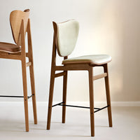 Light wood bar stool with a soft, pale green seat and a minimalist design, featuring natural textures and clean lines.
