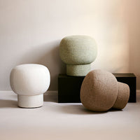 Three decorative stools in white, green, and beige with textured finishes against a neutral backdrop.