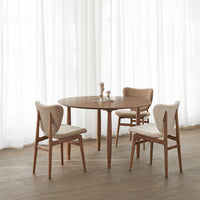 Light wood dining table with beige upholstered chairs, featuring a minimalist design and soft color palette.