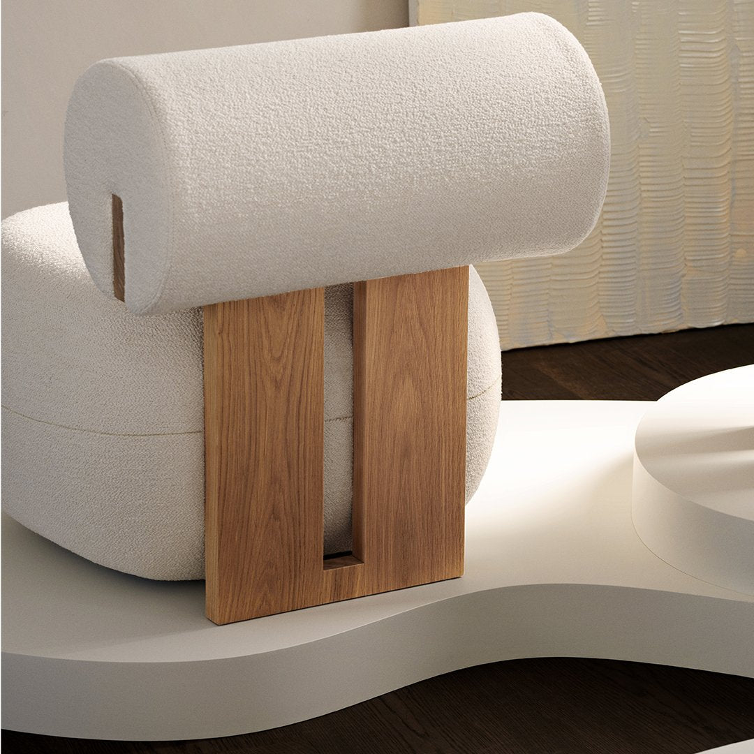 White textured cushion with a rounded design, paired with a natural wood accent in a modern, minimalist setting.