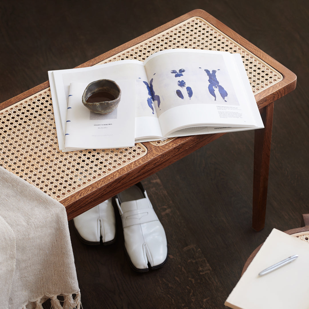Natural wood table with woven cane pattern, showcasing a neutral color palette with white and blue accents.