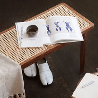 Natural wood table with woven cane pattern, showcasing a neutral color palette with white and blue accents.