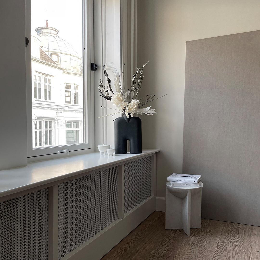 "Minimalist room featuring neutral tones, white floral accents, and textured surfaces for a modern aesthetic."