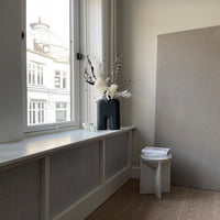 "Minimalist room featuring neutral tones, white floral accents, and textured surfaces for a modern aesthetic."