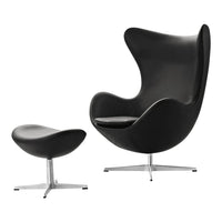 Modern black egg chair and matching ottoman with smooth, sleek surfaces and minimalist design. Ideal for contemporary decor.