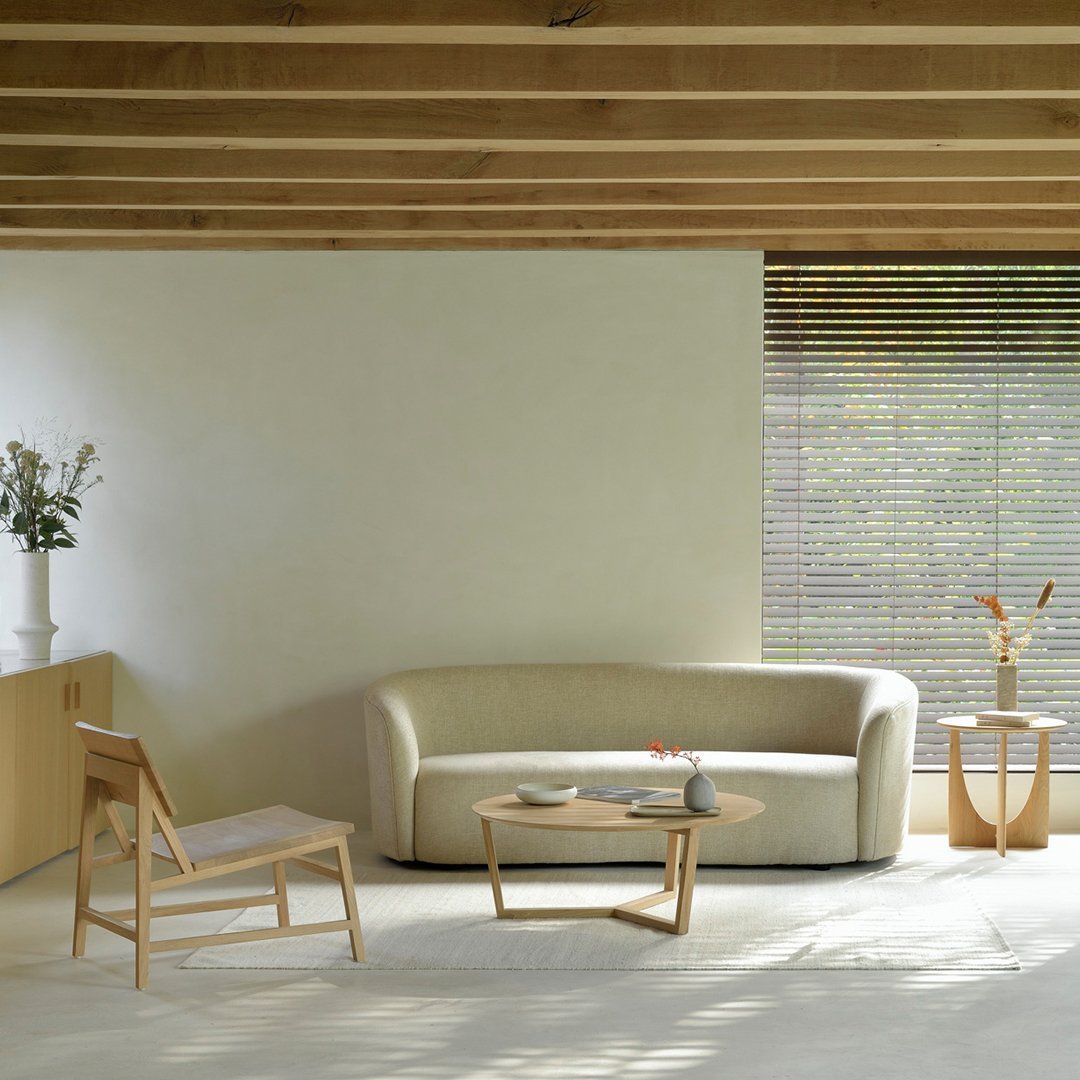 Cream sofa with wood accents, light beige walls, and natural wood ceiling, complemented by soft textured furnishings.