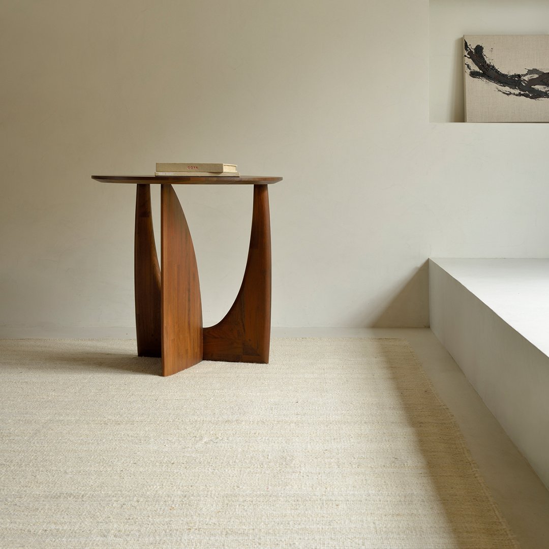 Stylish wooden side table with a rich brown finish and sleek, curved design against a light beige background.
