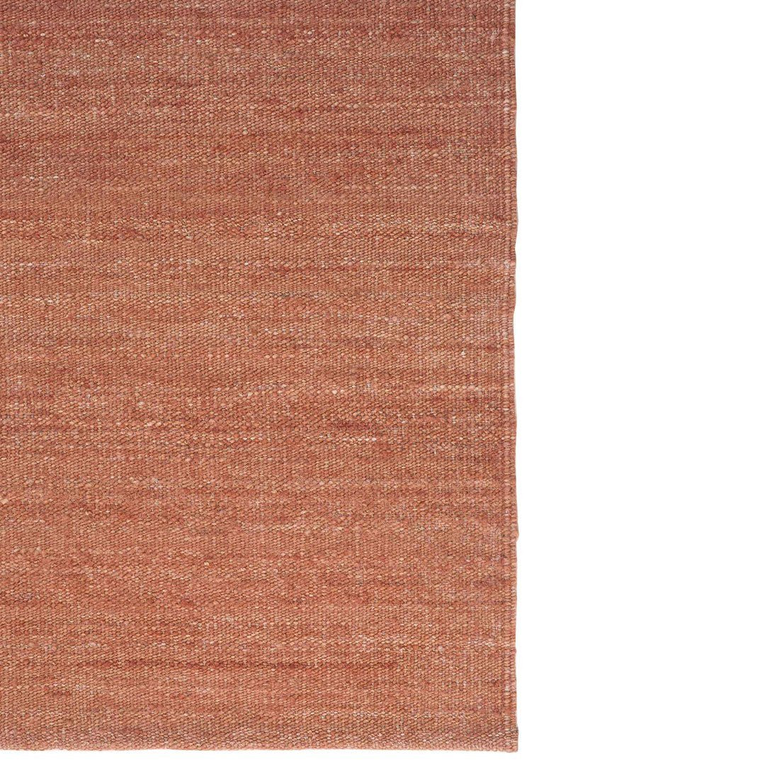 Soft terracotta rug with subtle textured patterns, perfect for adding warmth to any space.