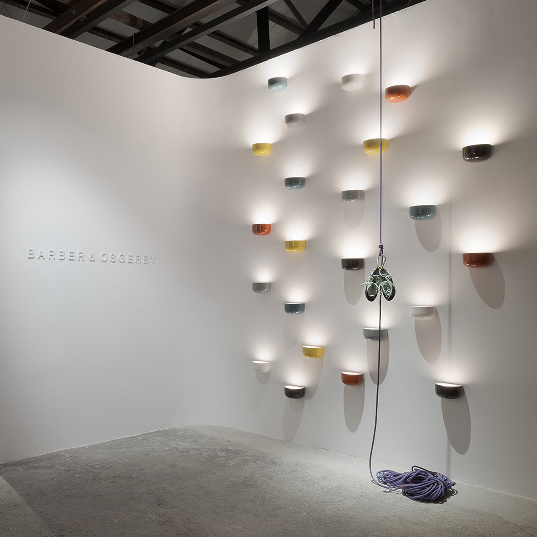 Colorful wall-mounted lights in varied shades, including yellow, orange, and blue, arranged in a modern pattern.