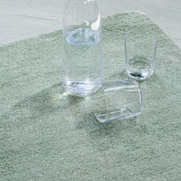 Soft green rug with a textured pattern, featuring a calming, natural aesthetic. Perfect for enhancing any space.