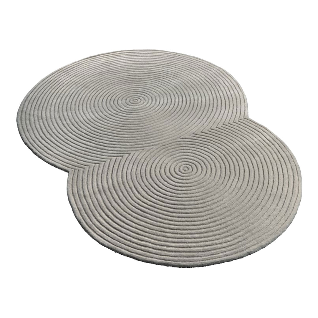 Circular, light gray rug set with spiral textured pattern, perfect for minimalist decor.