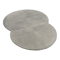 Gray circular rug featuring spiral patterns, perfect for modern home decor. Soft texture and stylish design.