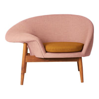Pink upholstered chair with a curved design, featuring a golden-yellow cushion and natural wood legs.
