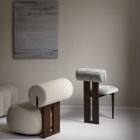 Neutral-toned upholstered chairs with soft curves, featuring a mix of textured fabrics and minimalist wooden bases.