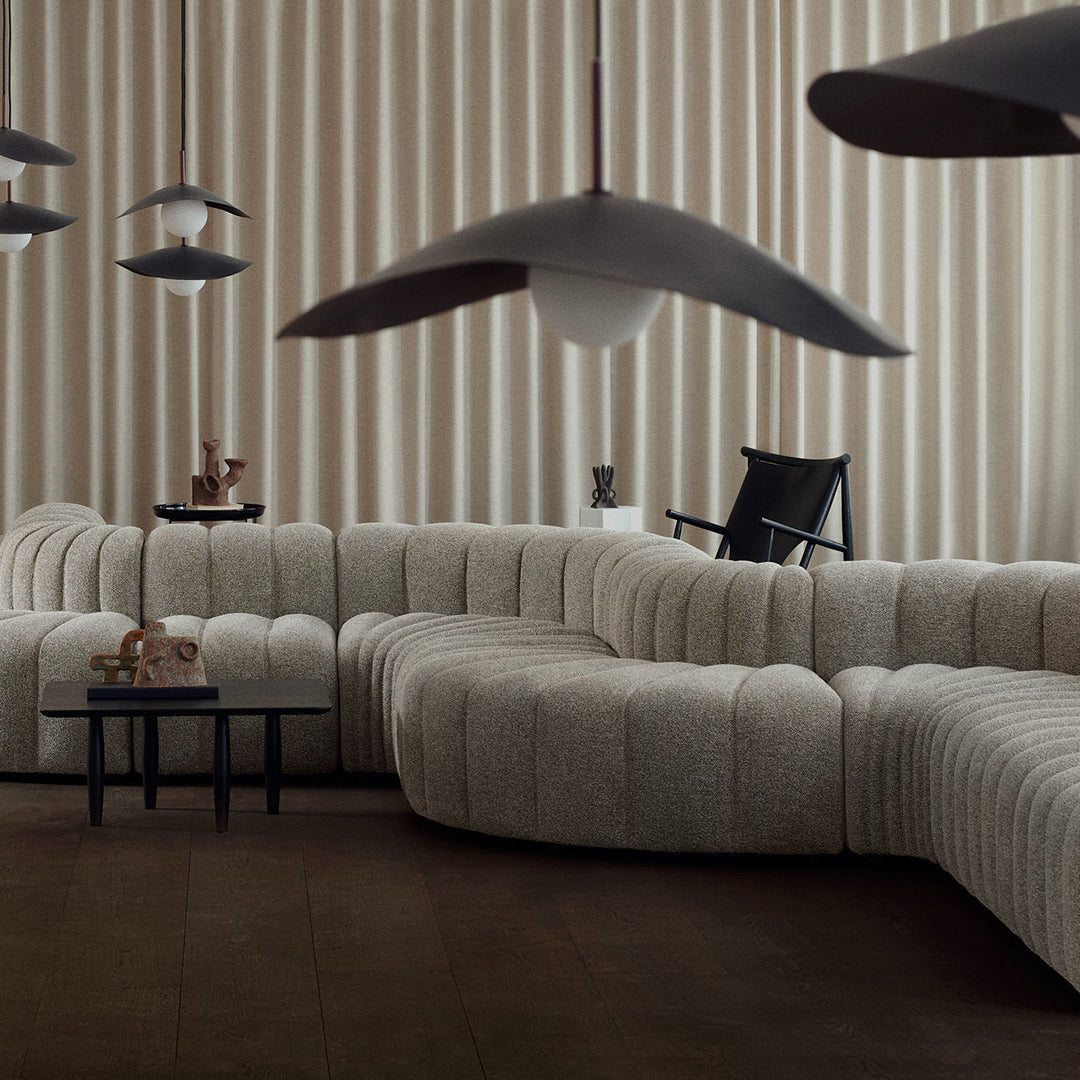 Soft beige sofa with subtle textures, complemented by dark wooden accents and elegant light fixtures.