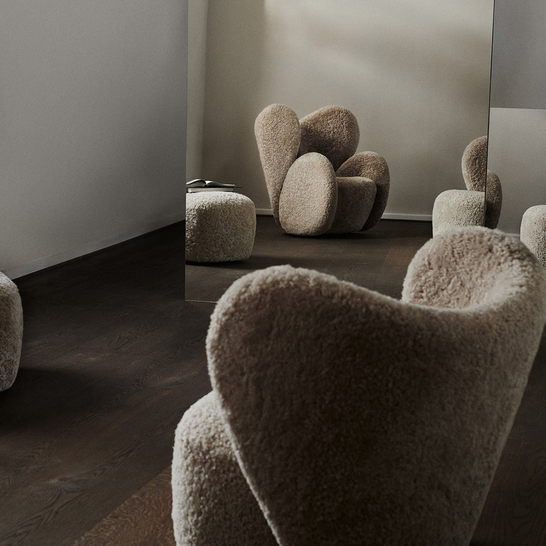 Cozy beige chairs with fluffy textures in a minimalistic setting, featuring soft curves and earthy tones.