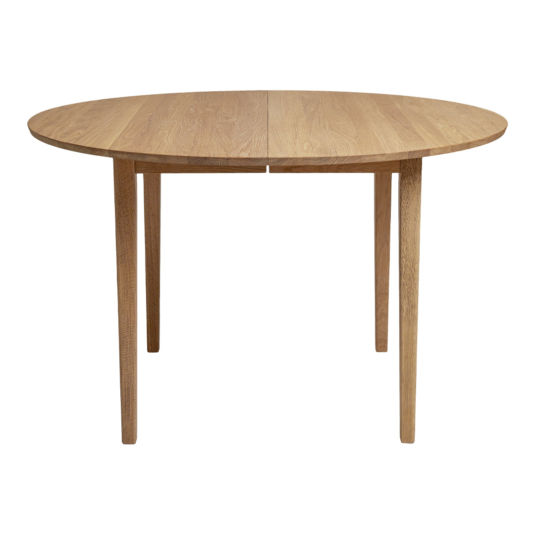 Light oak oval dining table with a smooth finish and natural wood grain pattern.