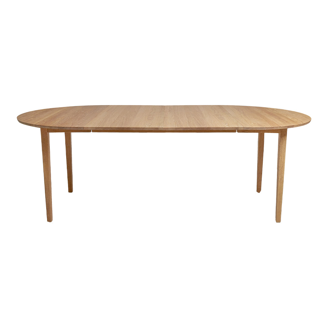 Light oak oval dining table with a smooth surface and natural wood grain pattern, perfect for modern interiors.