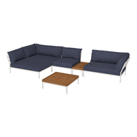 Navy blue sectional sofa with sleek silver legs and a natural wood table, featuring a contemporary design.