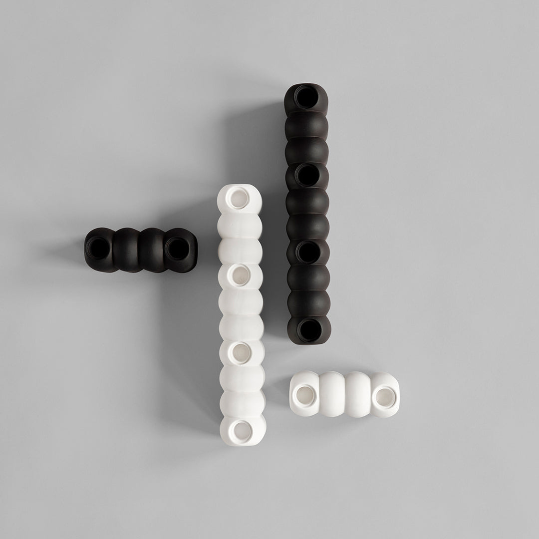 Black and white silicone beads in varying sizes and patterns, arranged artistically on a gray background.