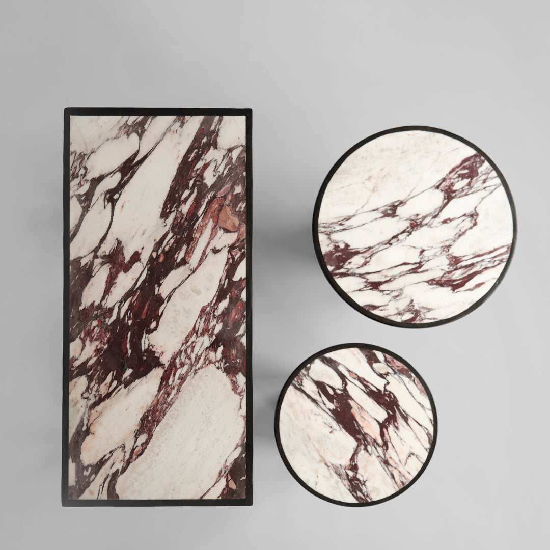 Elegant marble tables featuring rich red and white swirling patterns, perfect for modern decor.
