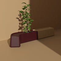 "Curved planter in deep burgundy and neutral beige, featuring smooth, modern lines against a warm background."