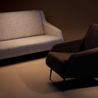 Two modern sofas: one in light beige textured fabric, the other in dark brown soft upholstery, stylish with minimalist design.