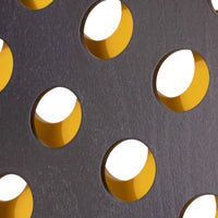 Black textured surface with circular cutouts featuring bright yellow edges, creating a modern geometric pattern.
