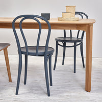 "Gray bentwood chairs paired with a light wood table, featuring a clean, minimalist design and contemporary aesthetic."