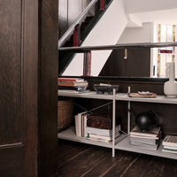Modern shelving unit with sleek silver accents, white surfaces, and rich dark wood contrasting with minimal decorative elements.