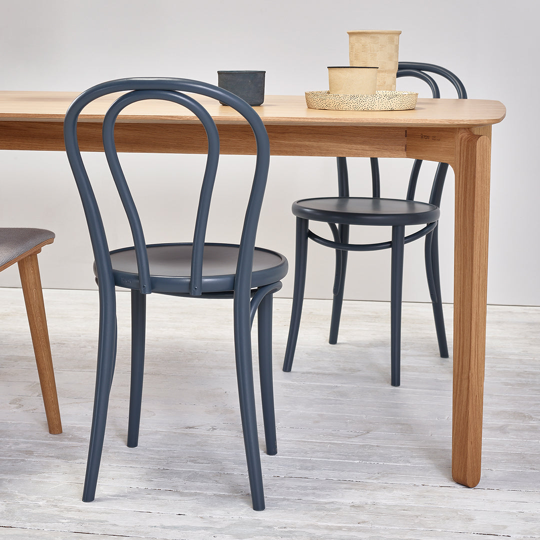 Blue curved chairs paired with a light wood table, showcasing a modern, minimalist design and neutral color palette.